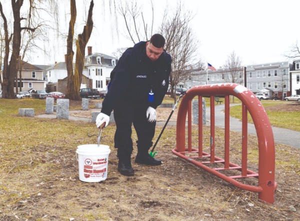 Andres Gonzalez, Program Coordinator for the new Syringe Collection Program in Lowell, safely removes a needle that had been discarded in Armory Park. Photo courtesy of the Lowell Health Department.